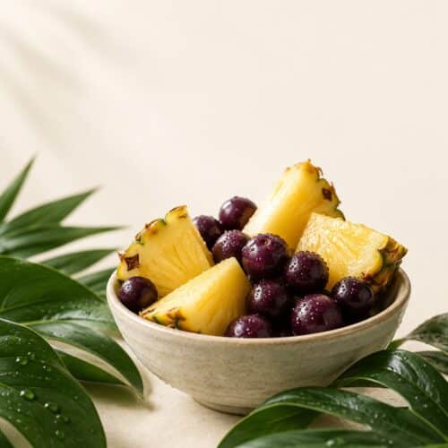 Ananas und Acai-Beeren auf cremefarbenem Hintergrund